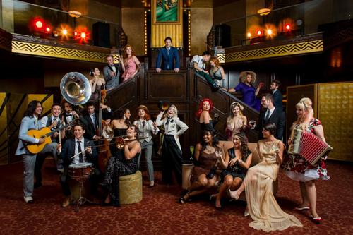 who is the woman with the deep cut out dress next to the bright red hair woman in black?